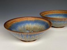 two blue and brown bowls sitting next to each other