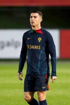 a man standing on top of a soccer field wearing a blue and red uniform with the word sagres written on it