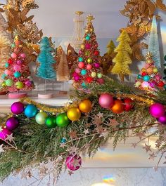 colorful christmas decorations on a mantel in front of a fireplace