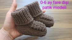 a hand holding up a pair of knitted baby booties with the words o - pay fare dis patik modeli