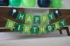 a happy birthday banner with green and black balloons in the background, along with other decorations