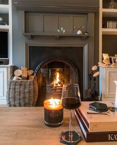 two glasses of wine sitting on a table next to a fireplace in a living room