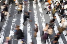 many people are walking across the cross walk