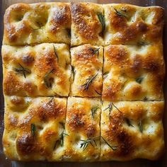 square cut bread with rosemary on top sitting on a cutting board