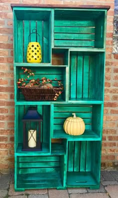 an old bookcase is painted green and has pumpkins on the shelf in front of it