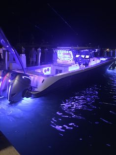 a boat that is sitting in the water with people standing on it's side