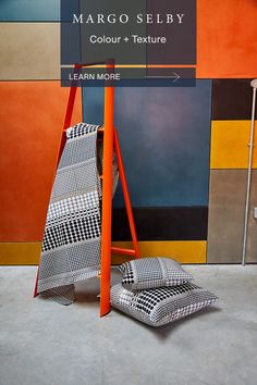 an orange and black chair next to a sign that says margo seley colours + texture