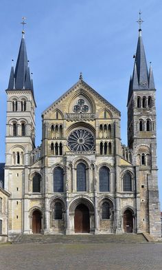 an old church with two towers and a clock on the front