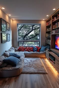 a living room filled with lots of furniture and a flat screen tv sitting on top of a wooden floor