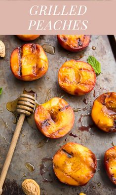 grilled peaches on a baking sheet with a fork