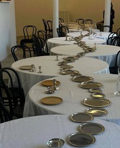 tables with white tablecloths and silver plates on them