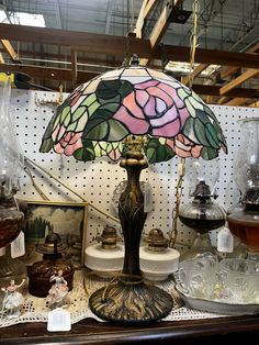 a lamp that is sitting on top of a table next to other glassware and items