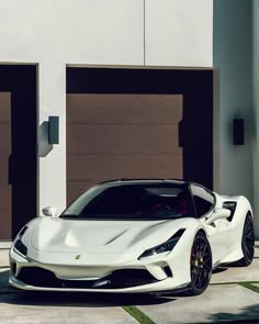 a white sports car parked in front of two garage doors