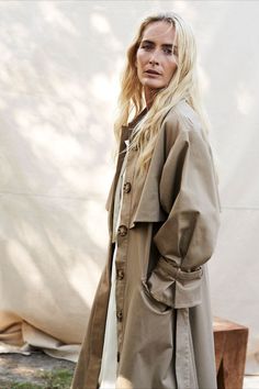 Varana's relaxed style belted trench coat, is cut from a water-resistant sand colour, drill fabric. Designed for a relaxed fit, it features mirrored storm flaps to the front and back, a drop shoulder and generous sleeve with leather covered buckled details and a deep box pleat at the back. A detachable belt is provided for a more fitted look.