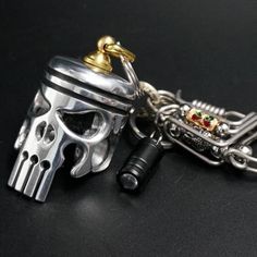 a silver skull with a golden crown on it's head is attached to a chain