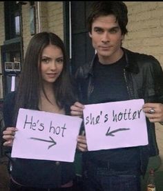 two people holding up signs that say he's hot and she's not