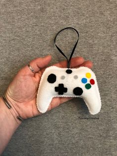 a hand holding a game controller ornament