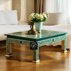 a green and white coffee table with flowers on top