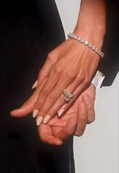 two people holding hands with rings on their fingers