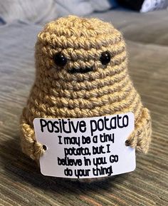 a crocheted stuffed animal holding a sign that says positive potato i may be a tiny potato but i believe in you can do your thing