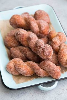 powdered sugar donuts in a white dish on a table