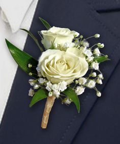 a boutonniere with white roses and baby's breath flowers on it