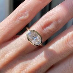 a woman's hand with a ring on it and a diamond in the middle