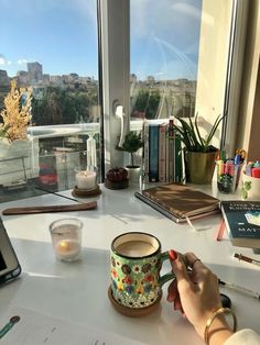 a person sitting at a desk with a laptop and coffee mug