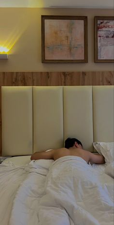 a man laying in bed with his head on the pillow