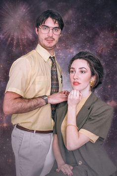 a man standing next to a woman with her hand on her chin, in front of a galaxy background