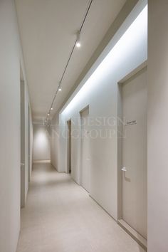 an empty hallway with white walls and lights