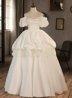 a white wedding dress on display in a room