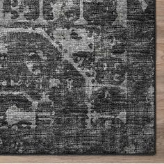 a black and white rug on top of a wooden floor