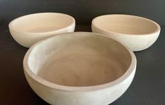 three white bowls sitting on top of a table