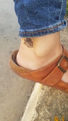 a close up of a person's foot with a small tattoo on their ankle