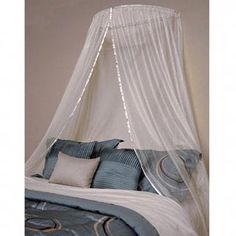 a canopy bed with blue and white pillows