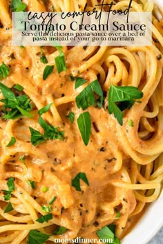 a white bowl filled with pasta covered in sauce and topped with parsley on top