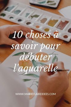 a person is painting with watercolors on paper and the words 10 choses a savoir pour debutter l'aquavrelle