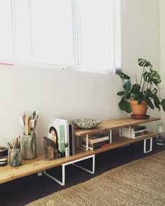 a wooden shelf with books and plants on it