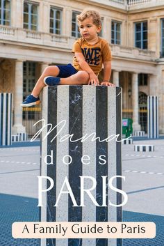 a little boy sitting on top of a sign