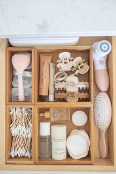 an organized wooden drawer with various items in it, including toothbrushes and other personal care products