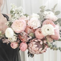 a woman holding a large bouquet of flowers