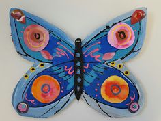 a blue butterfly with pink and orange designs on it's wings