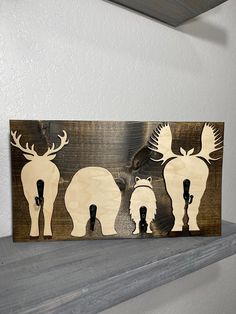 three moose silhouettes are mounted on a shelf