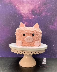 a cake that looks like a pig sitting on top of a table with space in the background