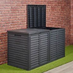 an outdoor storage box in front of a brick wall