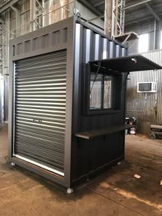 a large black container sitting in the middle of a warehouse with lots of metal doors