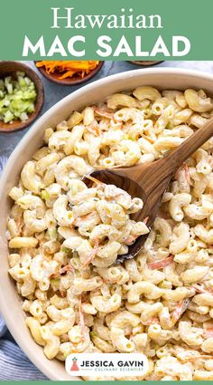 a bowl filled with macaroni salad and a wooden spoon on top of it