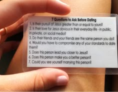 a person is holding a card that says questions to ask before dating