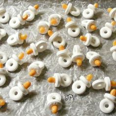 there are many white and orange beads on the table